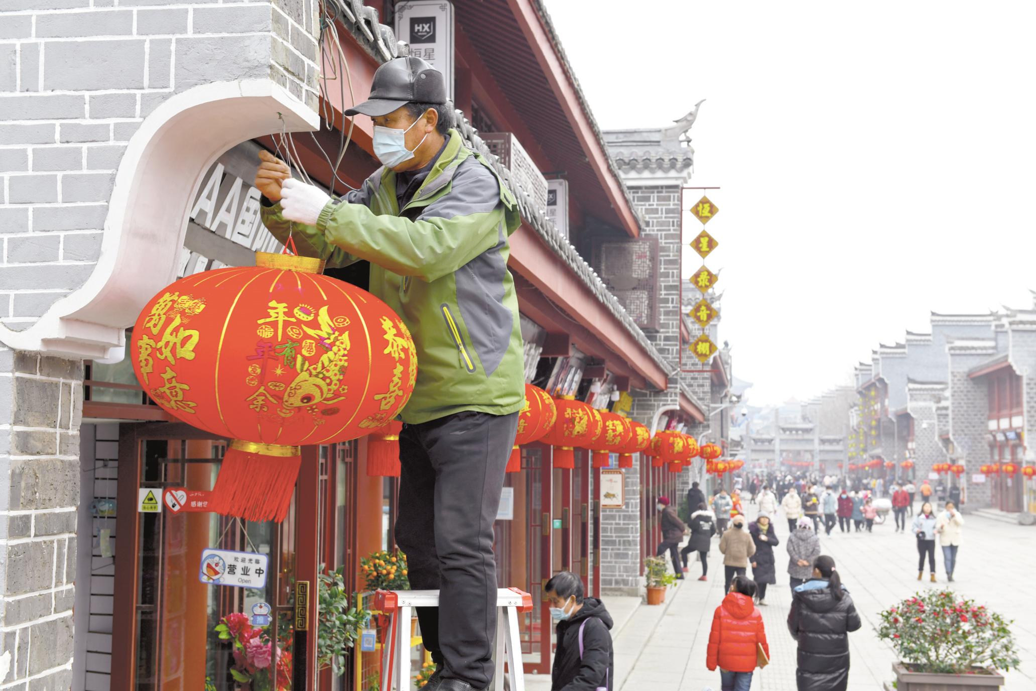 春節(jié)臨近，襄陽市住建局綠化管理處在市區(qū)多個路段掛起大紅燈籠，營造喜慶祥和的節(jié)日氛圍。（視界網(wǎng) 謝勇 史祎 攝）